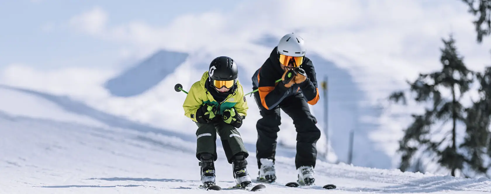 Kind und Erwachsener beim Skifahren auf einer Piste im Skicircus Saalbach Hinterglemm Leogang Fieberbrunn