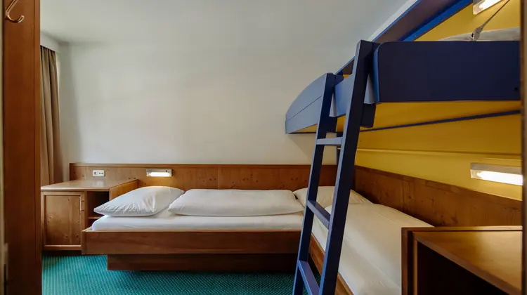 Room with single bed and blue loft bed with ladder