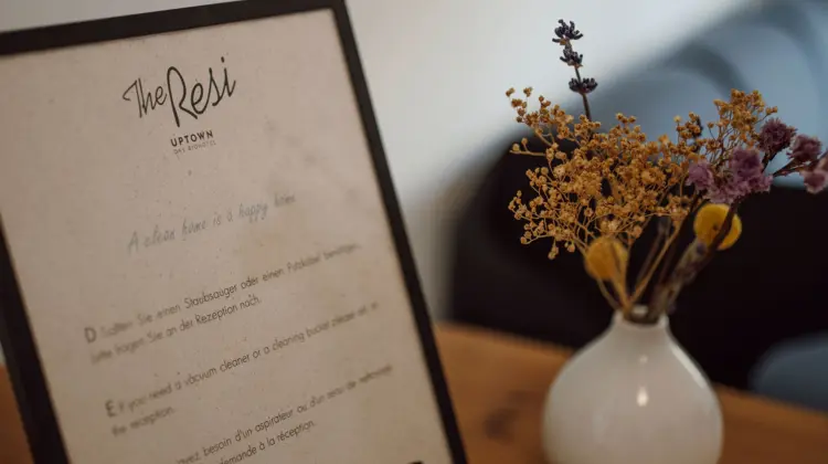 Sign with text next to vase with flowers on a table