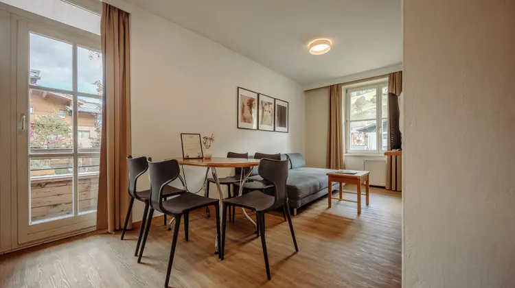 Living room with dining table, chairs, sofa and pictures on the wall