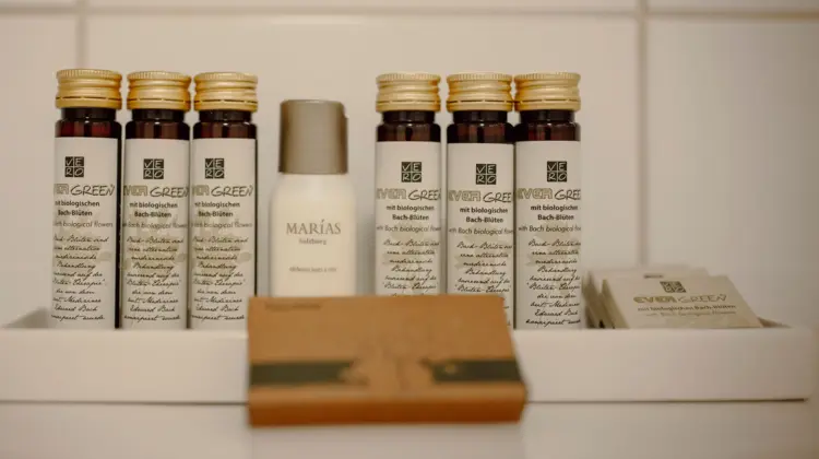Cosmetics on a white tray in front of white tiles