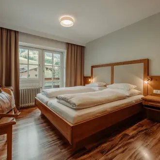 Schlafzimmer mit Doppelbett, Fenster und Blick ins Grüne