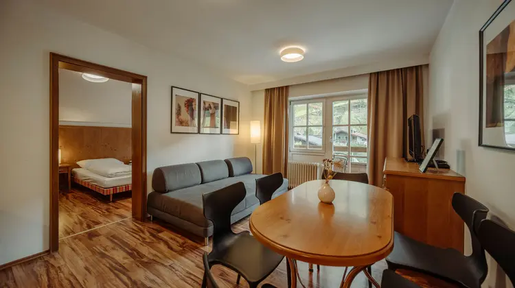 Wohnzimmer mit Sofa, Esstisch und Blick auf ein Schlafzimmer