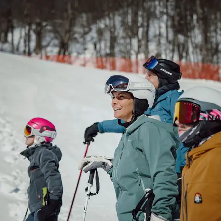 Skifahrer mit Helmen und Skibrillen blicken in verschneite Landschaft
