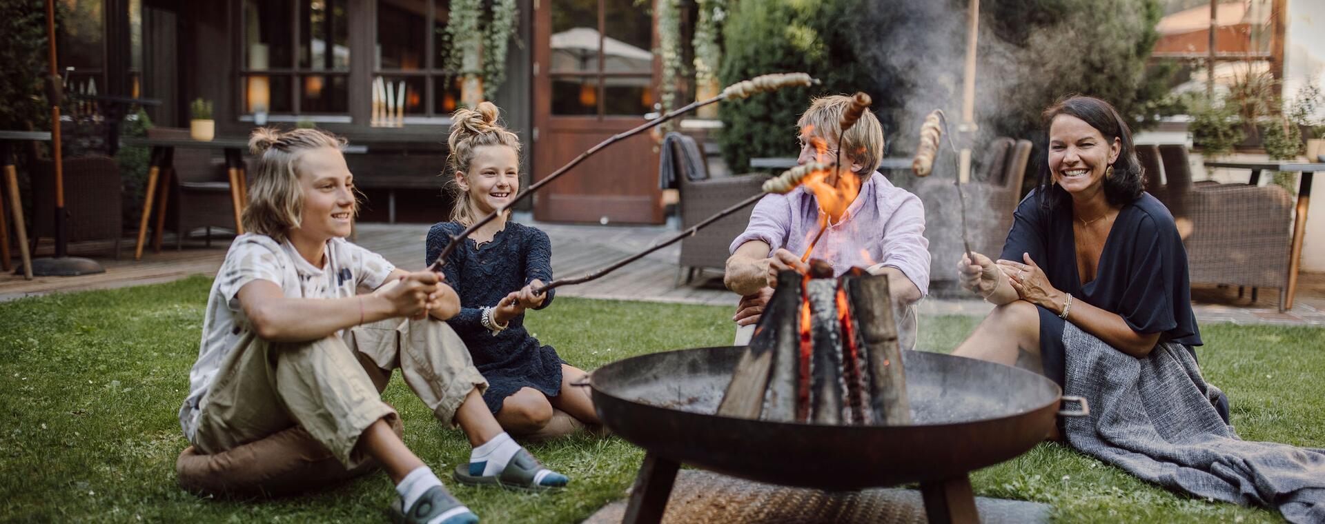 Familie grillt beim Lagerfeuer im Gartenhotel Theresia