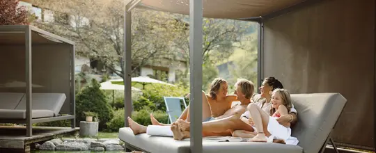 Eltern mit zwei Kindern am Hotelbadeteich Theresia