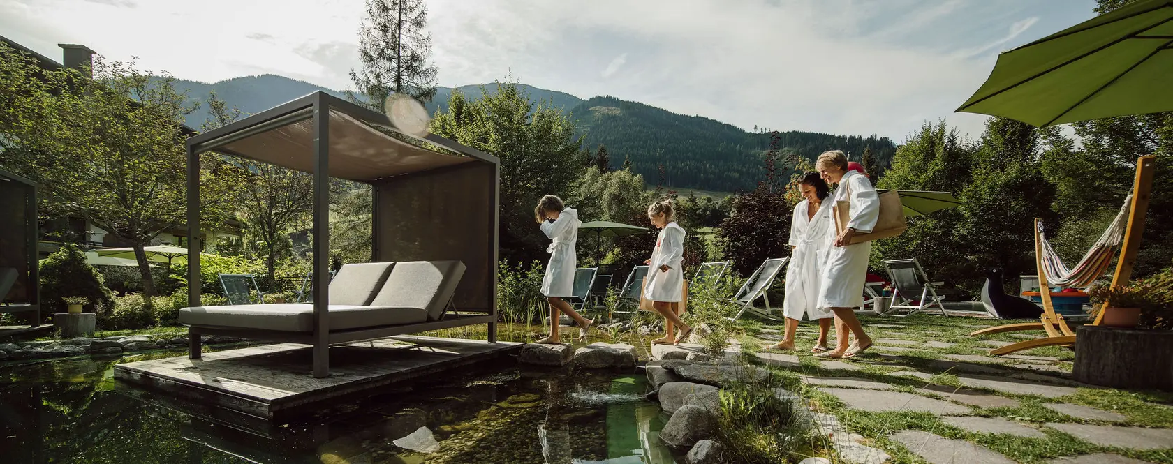 Parents with two children in bathrobes at the bathing pond