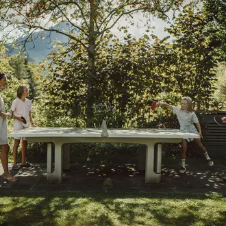 Familie spielt Tischtennis im Garten des Gartenhotel Theresia