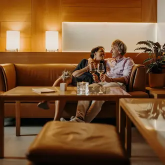 Pärchen in der Hotellounge beim Weintrinken