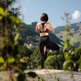 Woman doing yoga in front of mountain backdrop