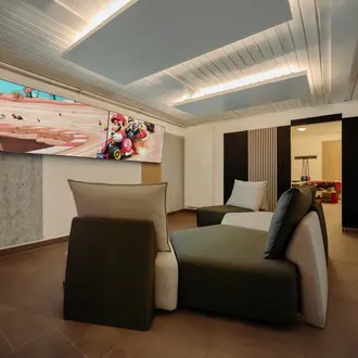 Wohnzimmer mit modularem Sofa, Mario Kart Bild und Deckenbeleuchtung
