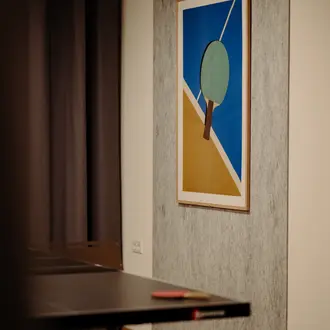 Abstraktes Bild einer Tischtenniskelle an Wand über Tischtennisplatte