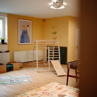 Gelbes Kinderzimmer mit Klettergerüst, Rutsche, Bild und Tischfußball