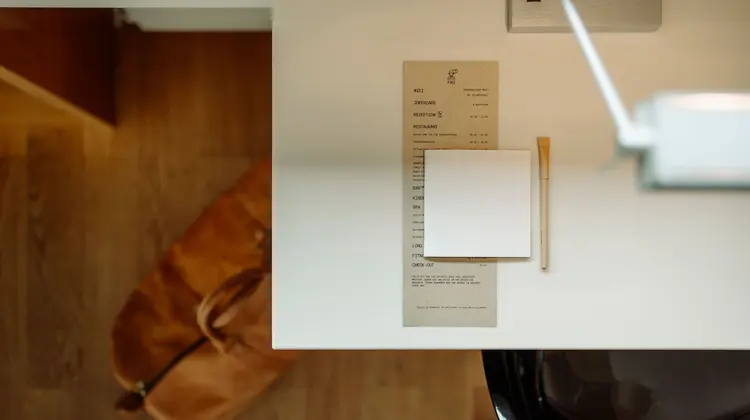 Tisch mit Speisekarte, Notizzettel und Stift von oben